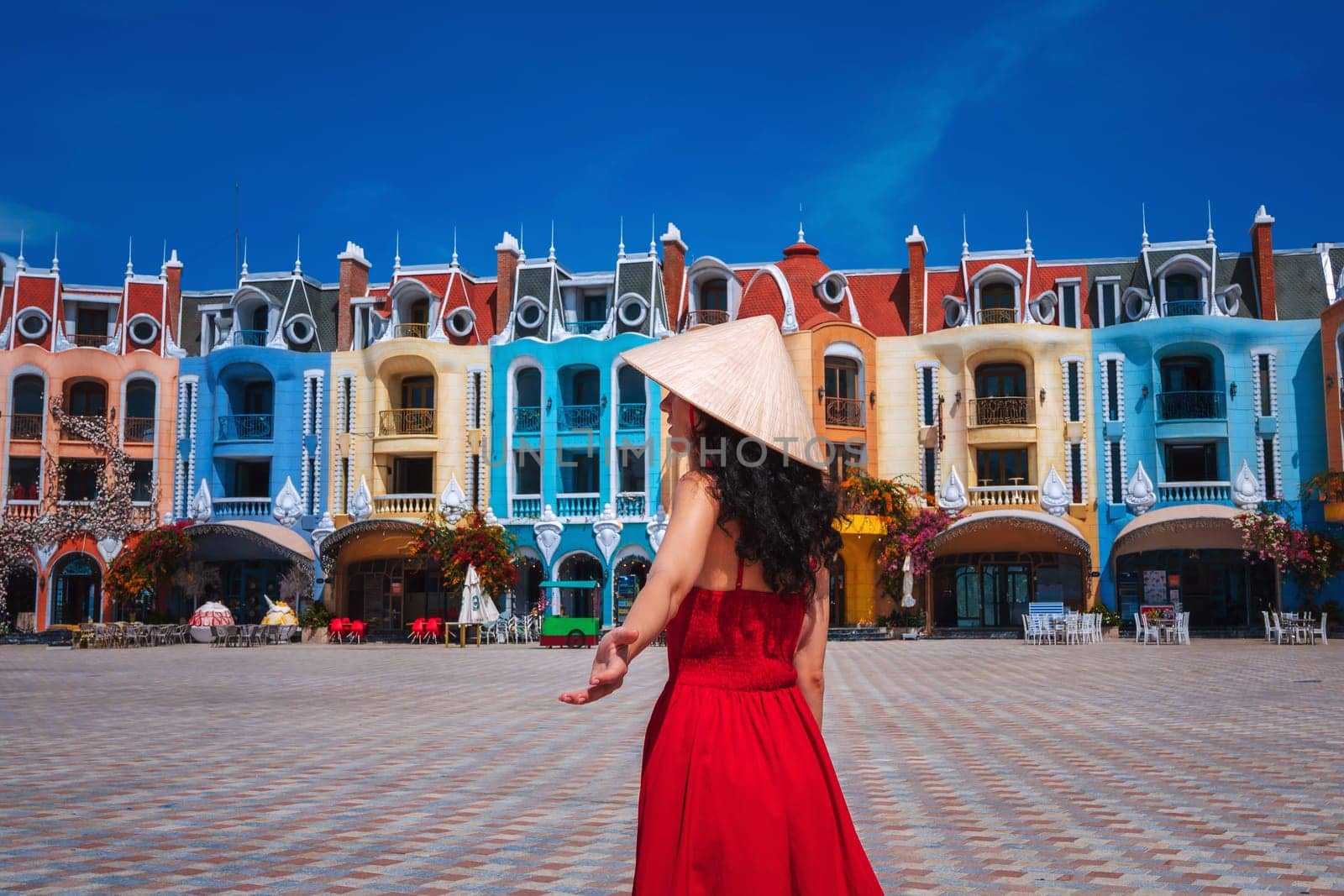 beautiful woman tourist traveler in Vietnamese hat on Vinpearl Island at VinWonders Amusement Park in Nha Trang at vacation in Asia. Travel and tourism in Vietnam. Follow me concept