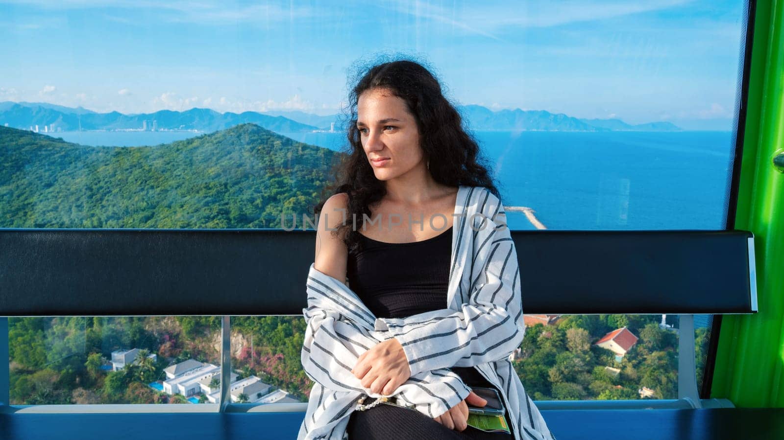 lonely young female tourist is enjoying vacation in a cabin on a cable car
