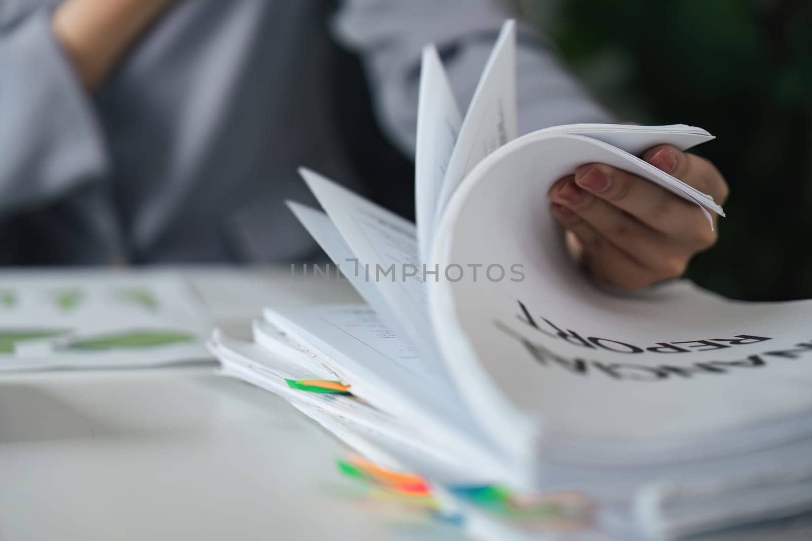 Close-up of a professional managing financial documents, illustrating the organization and attention to detail essential for effective reporting.