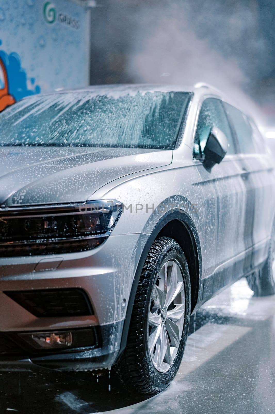 Wet soap suds running down the car at the car wash. High quality photo