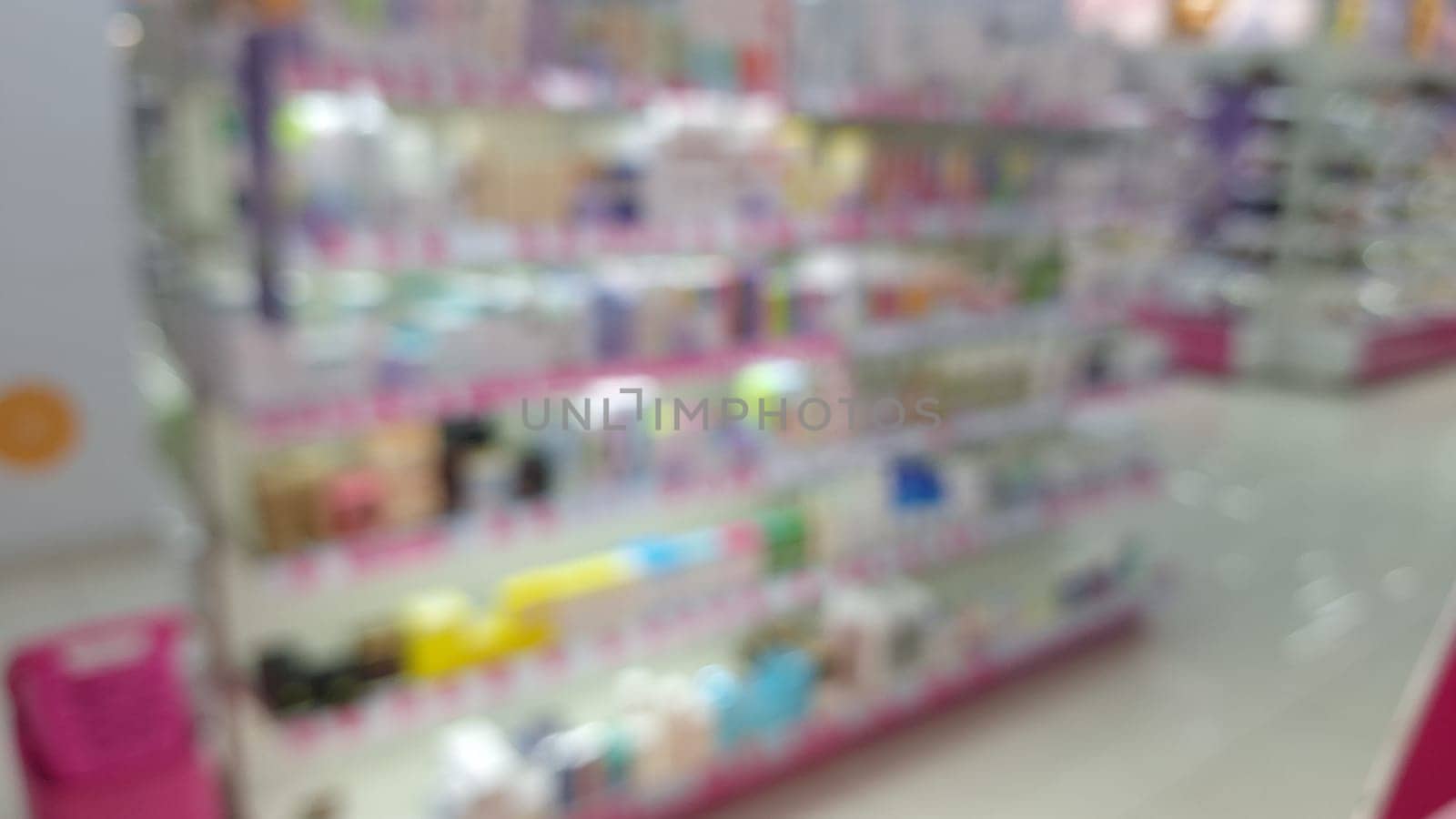 Blurred view of colorful pharmacy shelf display in modern store.