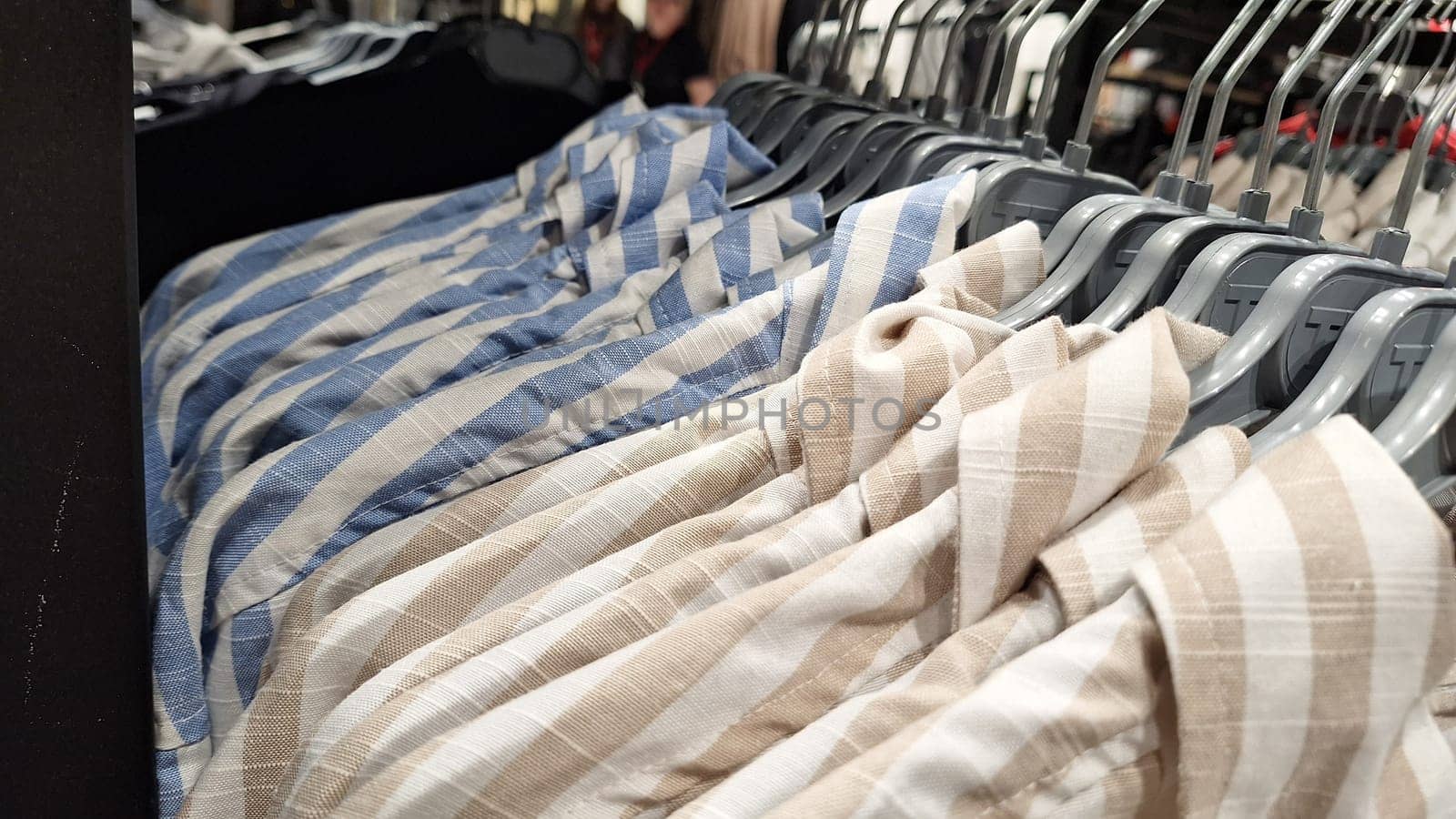 Striped shirts on display in clothing store.