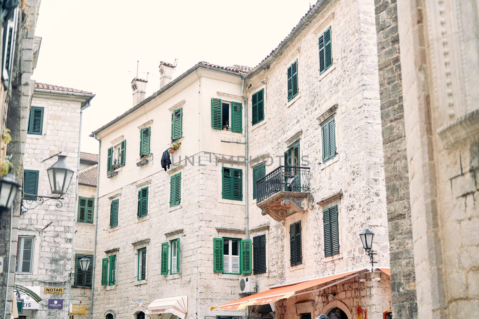 Ancient stone houses with green shutters on the windows on narrow streets. Kotor, Montenegro. High quality photo
