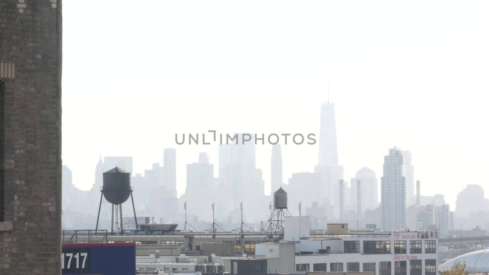 New York City, United States - 3 Sept 2023: Manhattan downtown financial district skyline cityscape. World Trade Center skyscraper. Rooftop water tower, tank on roof. Industrial buildings in Queens.