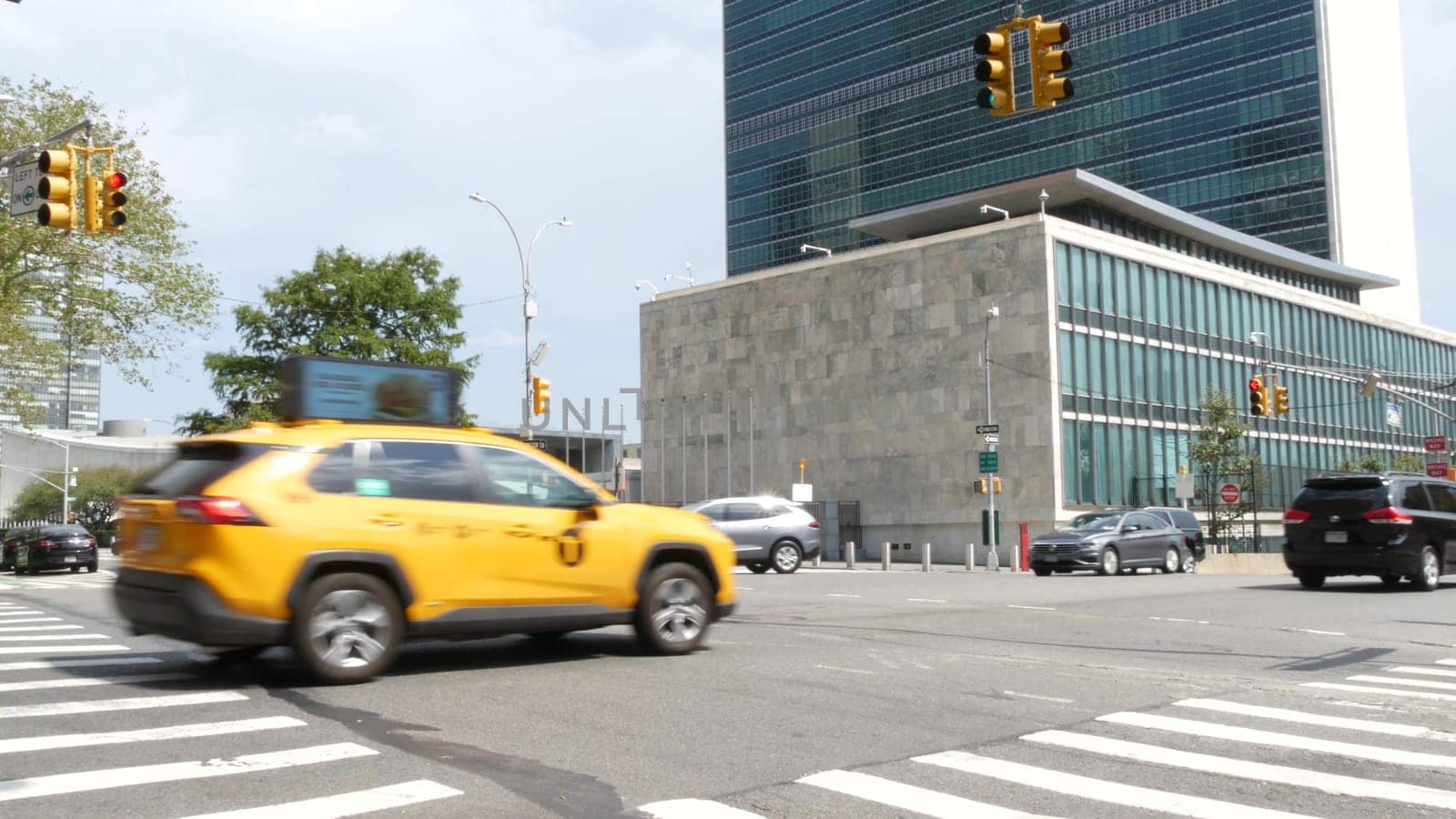New York City, United States - 4 Sept 2023: United Nations UN Headquarters, Manhattan Midtown, USA. Diplomatic political international organization, General Assembly. Street traffic, yellow taxi car.