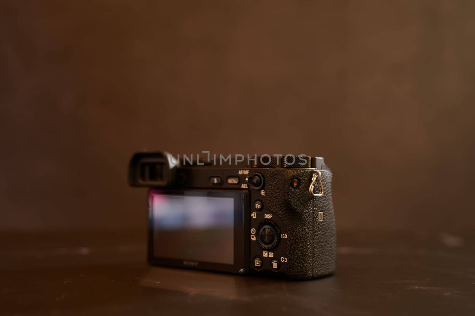 Sony A6000 digital mirrorless camera stands on a black marble table. Back view. High quality photo