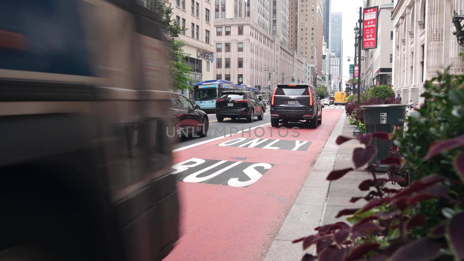 New York City, United States - 29 Aug 2023: Manhattan Midtown 34 street, near Herald Square, Broadway, 6 avenue. Urban road car traffic. Red bus lane for USA public transport. Yellow taxi cab, people.