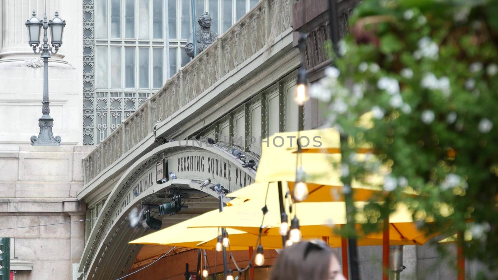 New York City, United States - 4 Sept 2023: Grand Central Terminal railway station, 42 street. American Manhattan Midtown. Bridge on Pershing Square, NYC, USA. Light bulb garland, umbrella and flowers