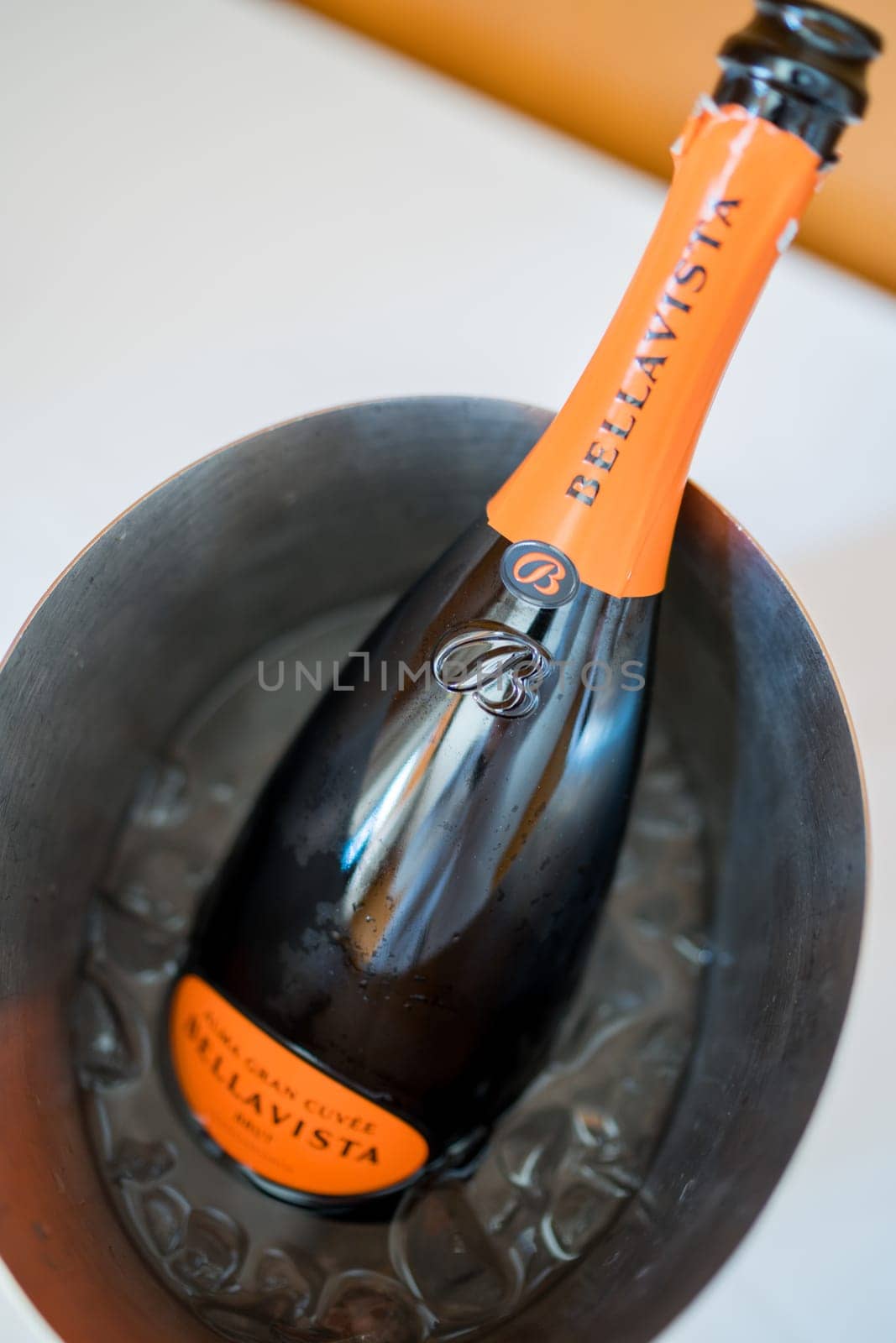 Open bottle of sparkling wine Bellavista stands in an ice bucket on the table. High quality photo