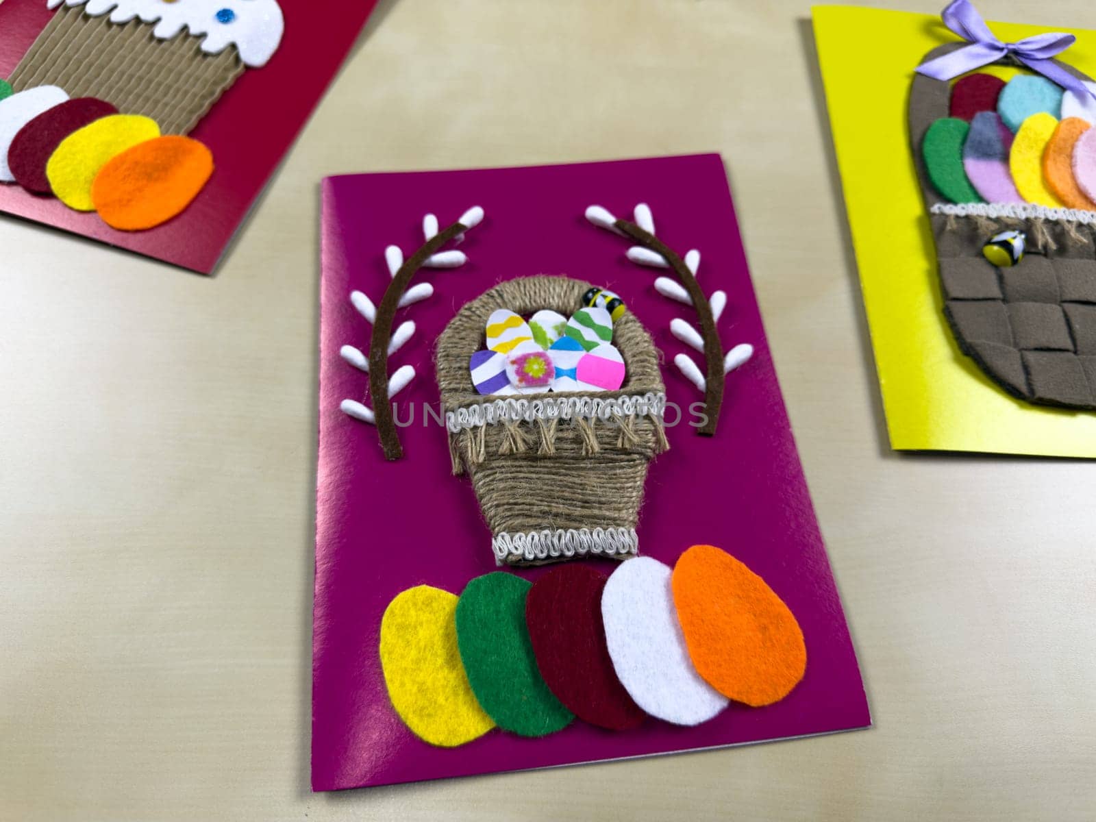 Vibrant handmade Easter card features basket filled with assorted felt eggs and cheerful decoration. Perfect for sharing warm wishes and celebrating joyful spirit of Easter with family and friends