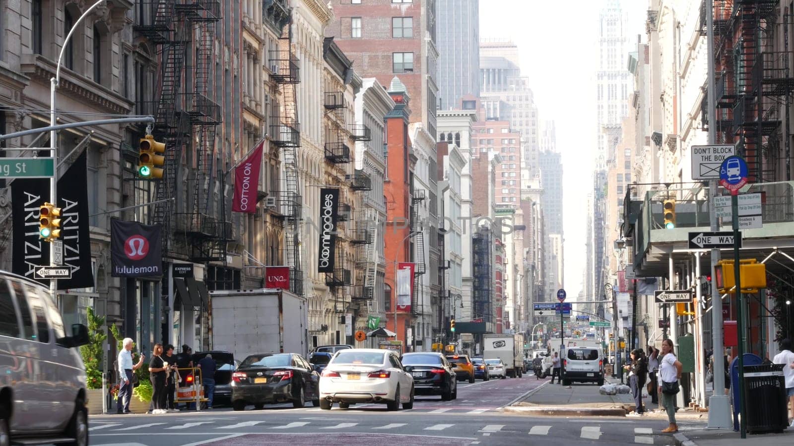 New York City, United States - 8 Sept 2023: Manhattan Soho District, Broadway street perspective. Urban road car traffic, yellow taxi, people. USA building architecture, Fashion stores for shopping.