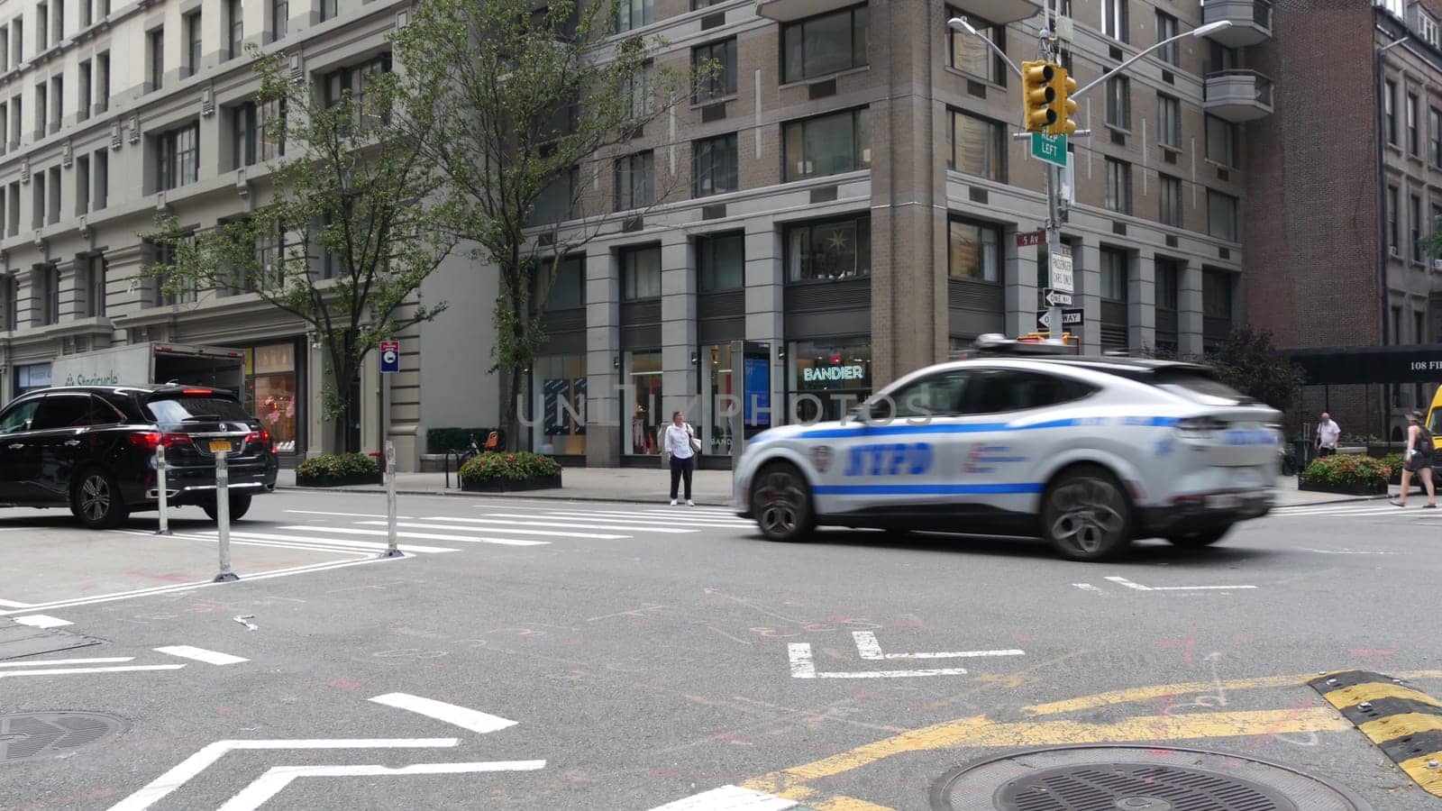 New York City, United States - 8 Sept 2023: Police patrol car, USA NYPD, 911 vehicle on Manhattan Midtown street. American cop auto siren light on Fifth 5 avenue. Urban traffic, road transport scene.