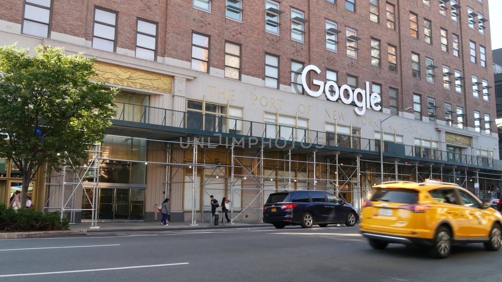 New York City, United States - 1 Sept 2023: Manhattan Midtown street or avenue. Urban red brick architecture USA. Google logo. Headquarters office near Chelsea Market, High Line. Yellow taxi cab car.