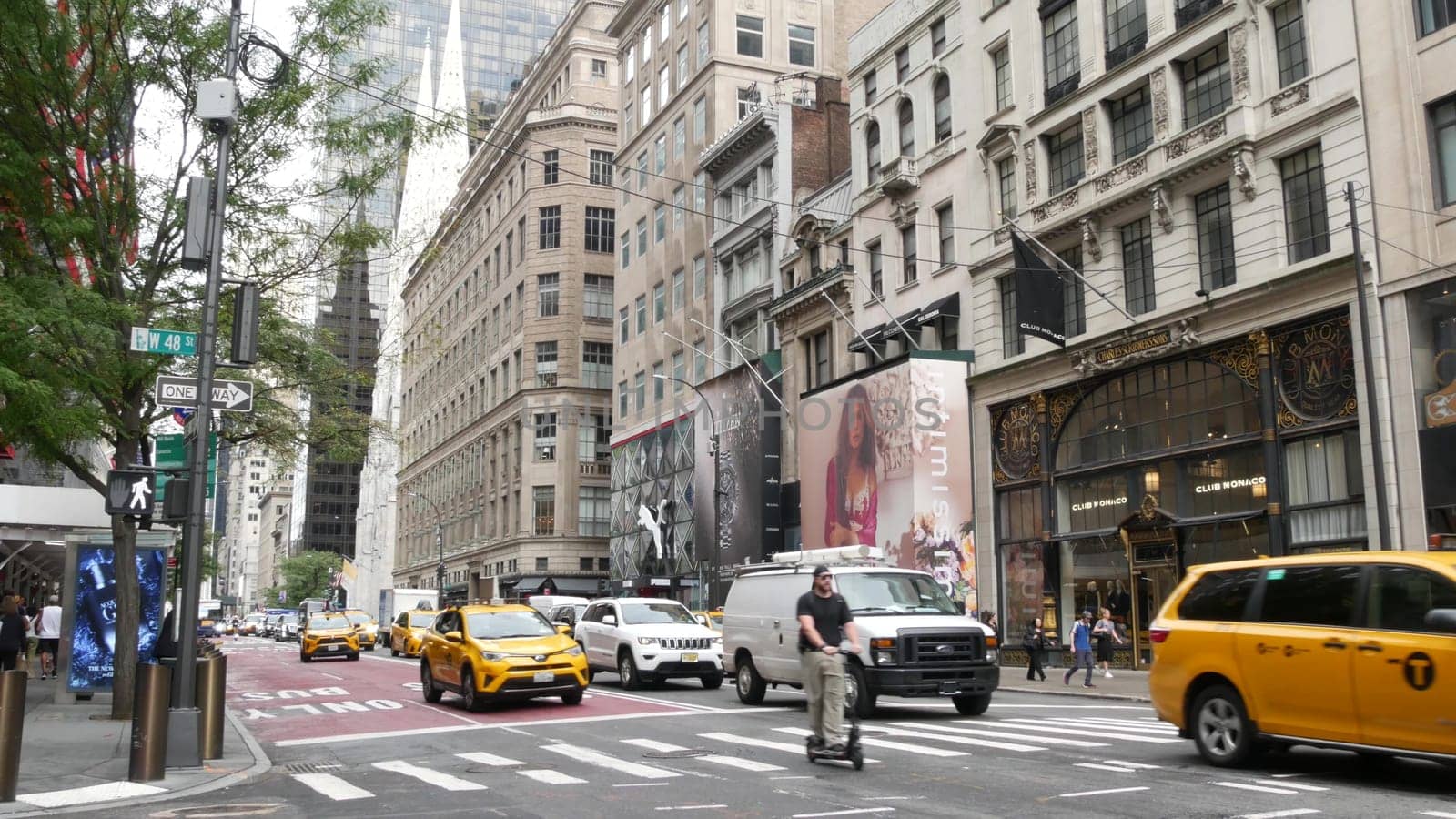 New York City, United States - 13 Sept 2023: Manhattan Midtown street, Fifth 5 avenue. American urban road car traffic. Yellow taxi cab in USA. People pedestrians. Boutique fashion stores for shopping