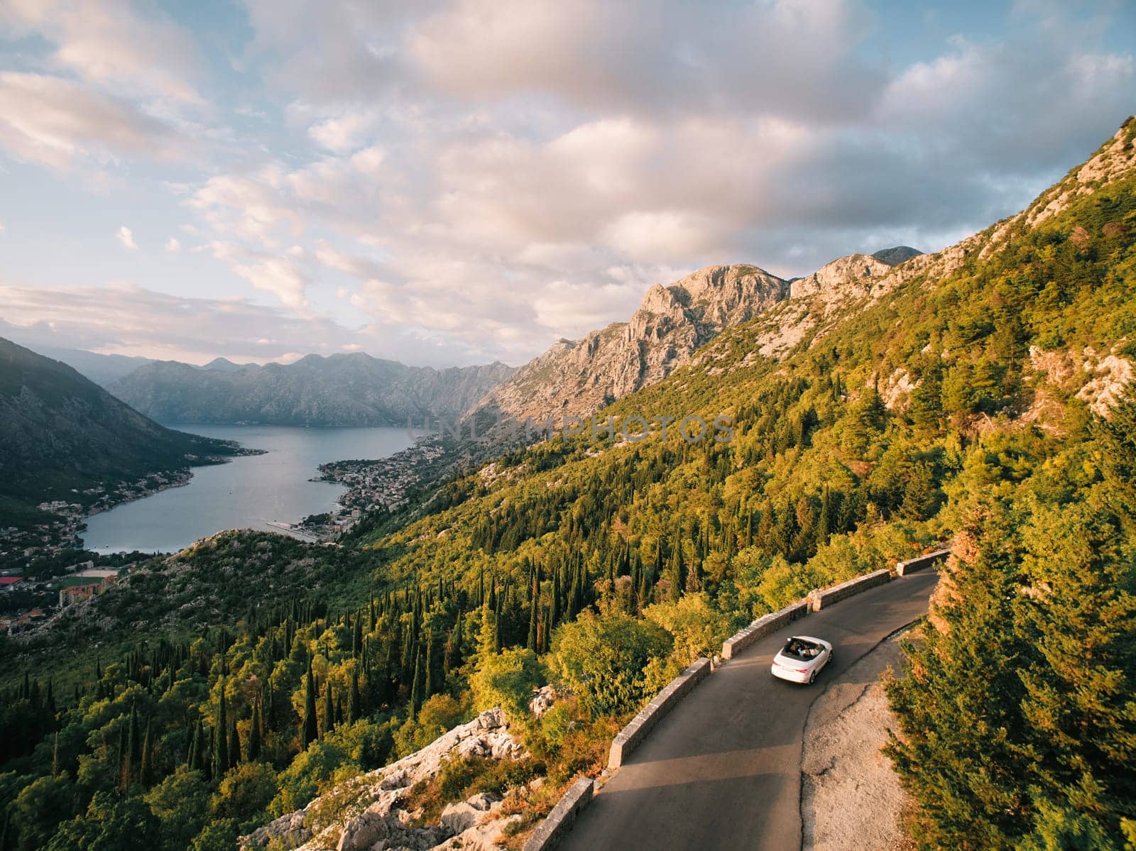 Convertible drives along the mountain highway above the Bay of Kotor. Montenegro. Drone. High quality photo