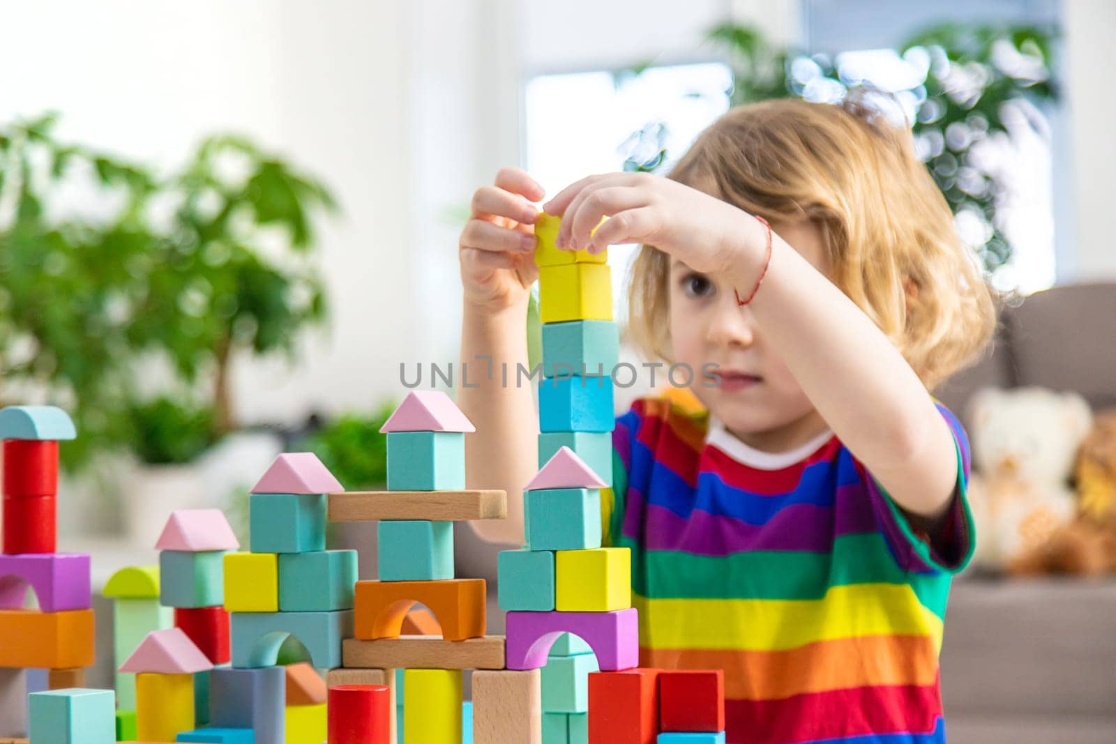 A child builds from blocks. Selective focus. kid.