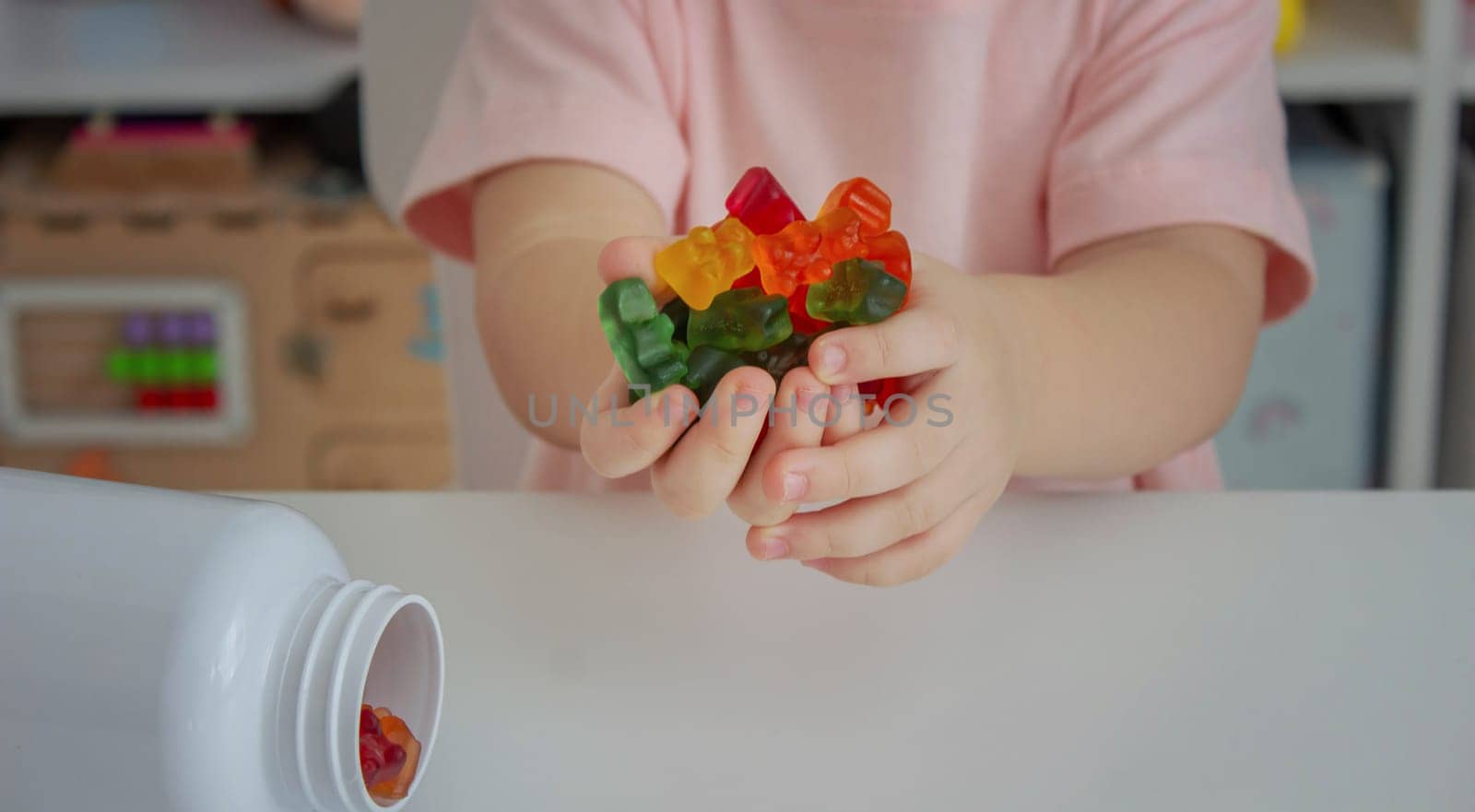 Little girl eating jelly candies or vitamins. child.