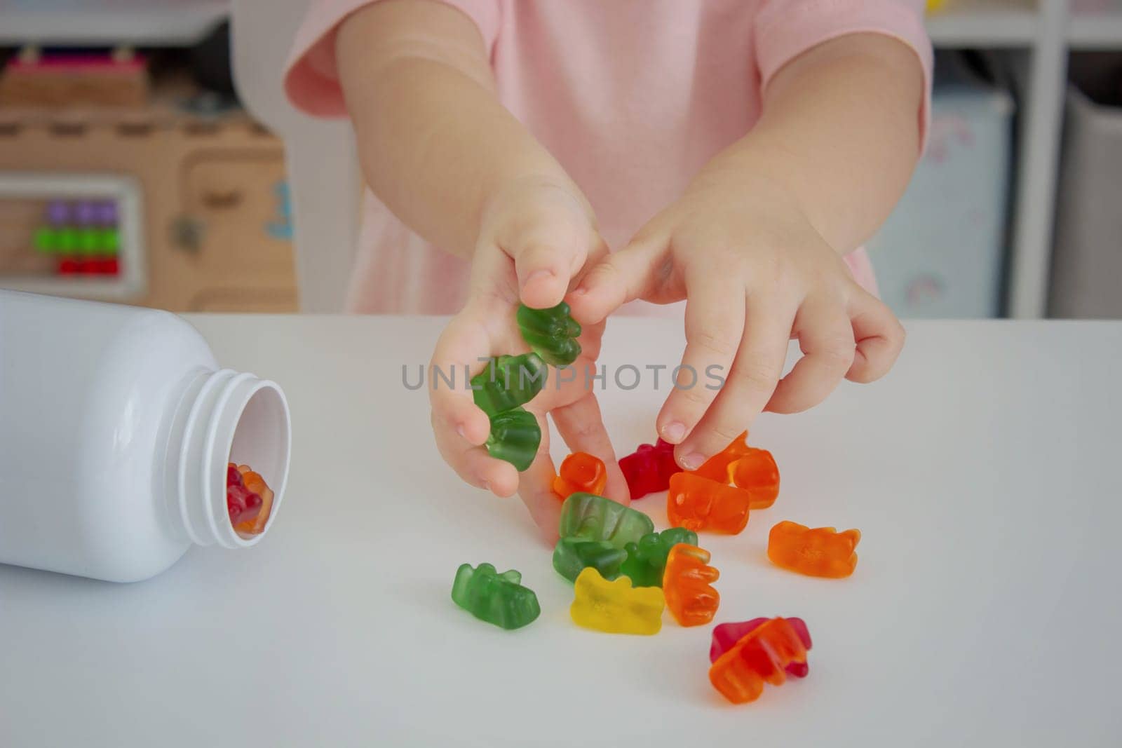 Little girl eating jelly candies or vitamins. child.