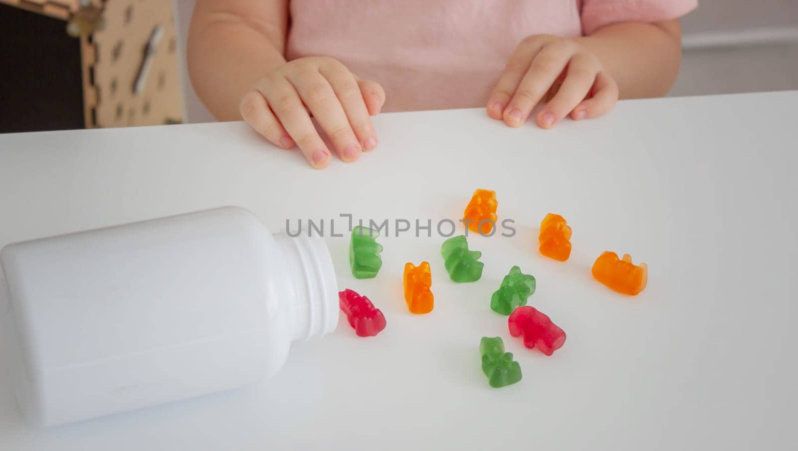Little girl eating jelly candies or vitamins. child.