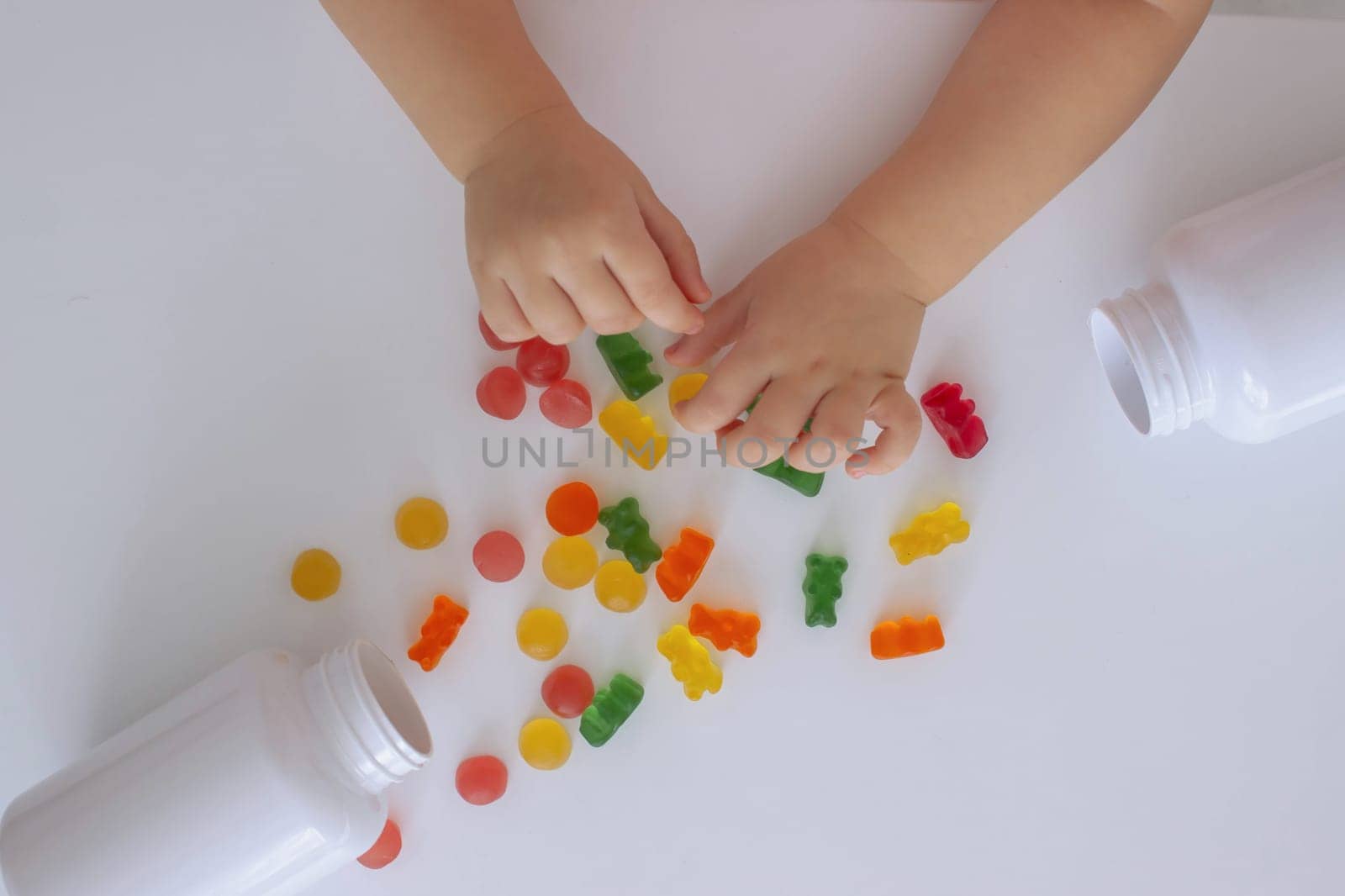close-up of a little girl's hand taking jelly beans or vitamins