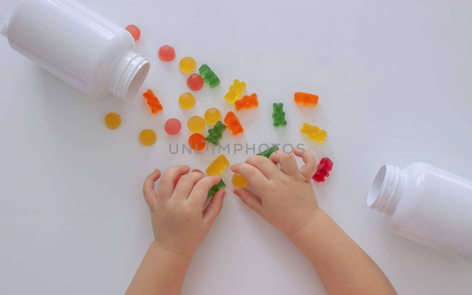 close-up of a little girl's hand taking jelly beans or vitamins