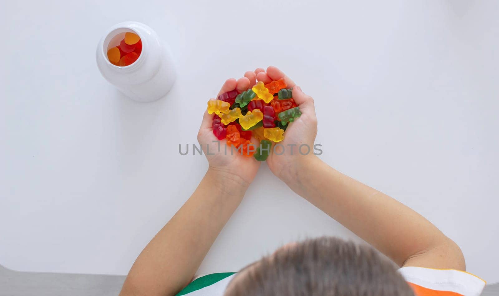 The boy eats jelly beans or takes vitamins.