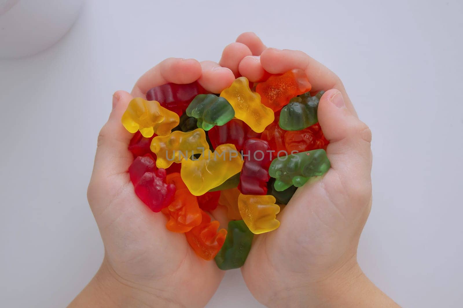 The boy eats jelly beans or takes vitamins.