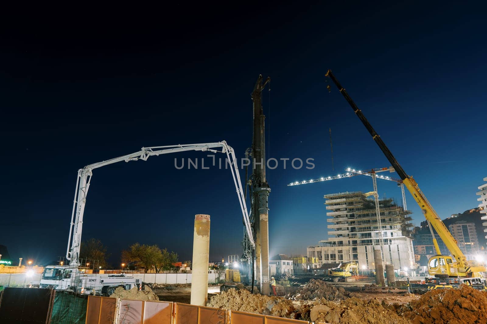 Illuminated drilling rigs work at night on a construction site. High quality photo