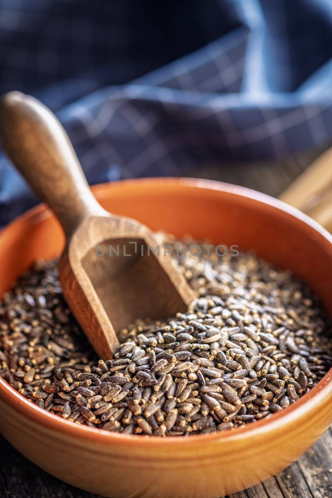 Milk thistle seeds in bowl on a wooden table.