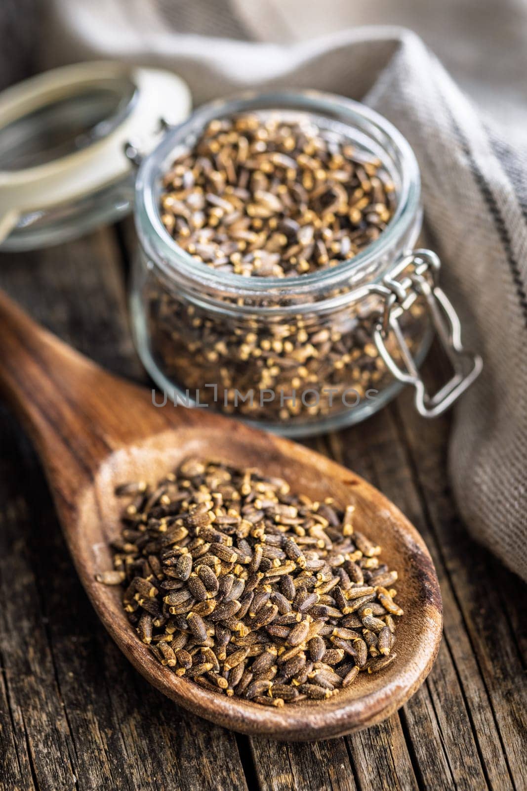 Milk thistle seeds on wooden spoon on a wooden table.