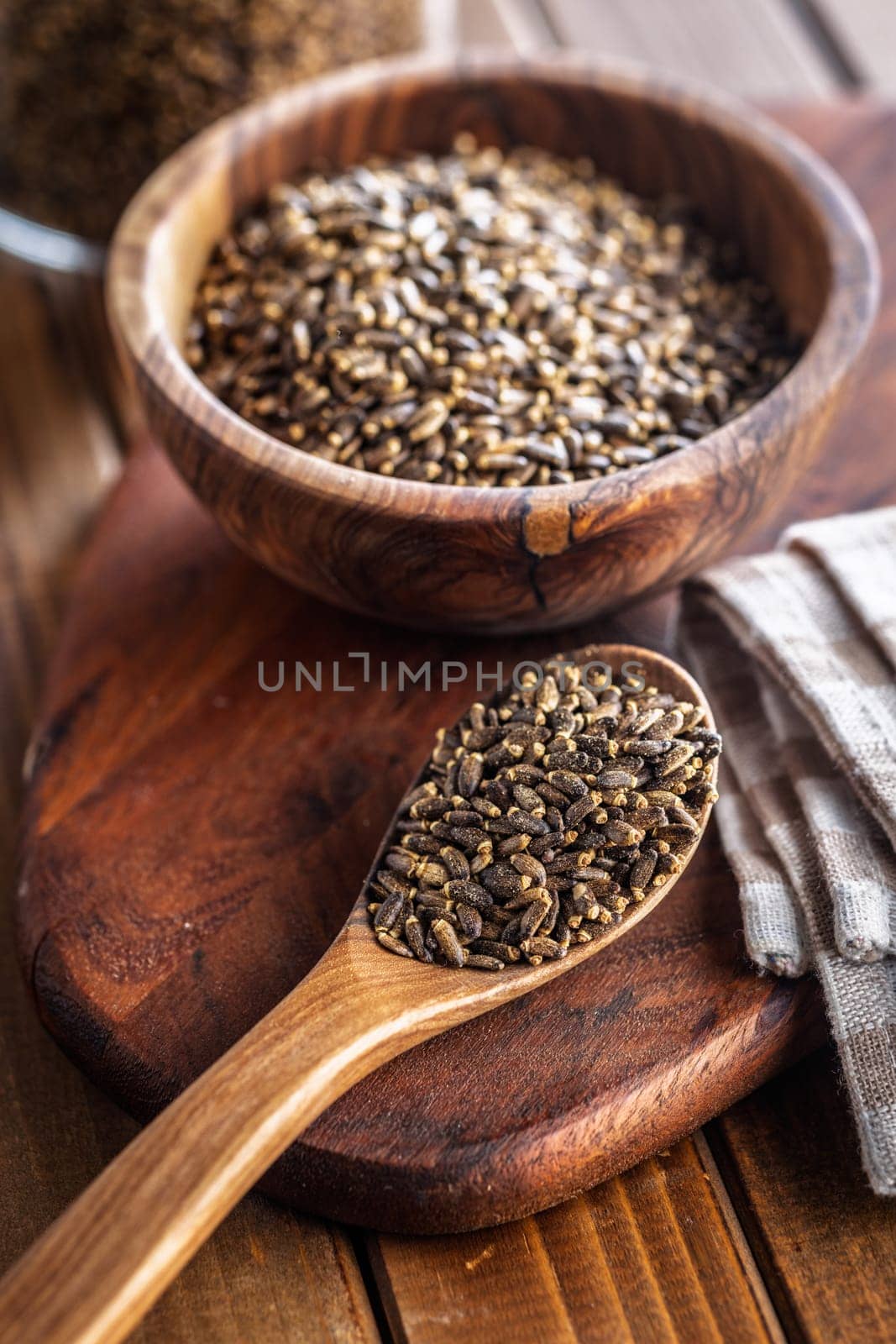 Milk thistle seeds on wooden spoon on a wooden table.