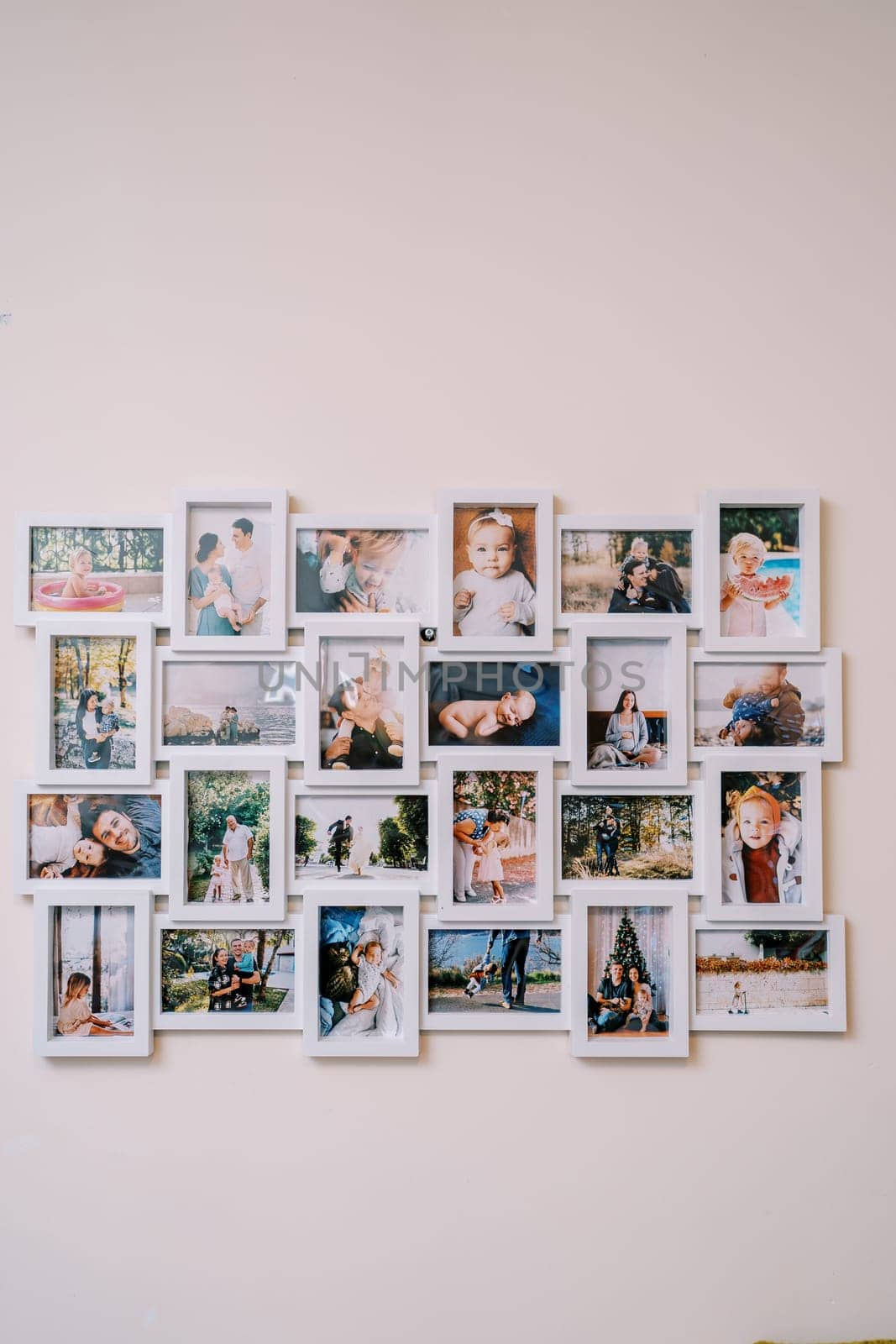 White photo collage frame with family photos hanging on the wall. High quality photo