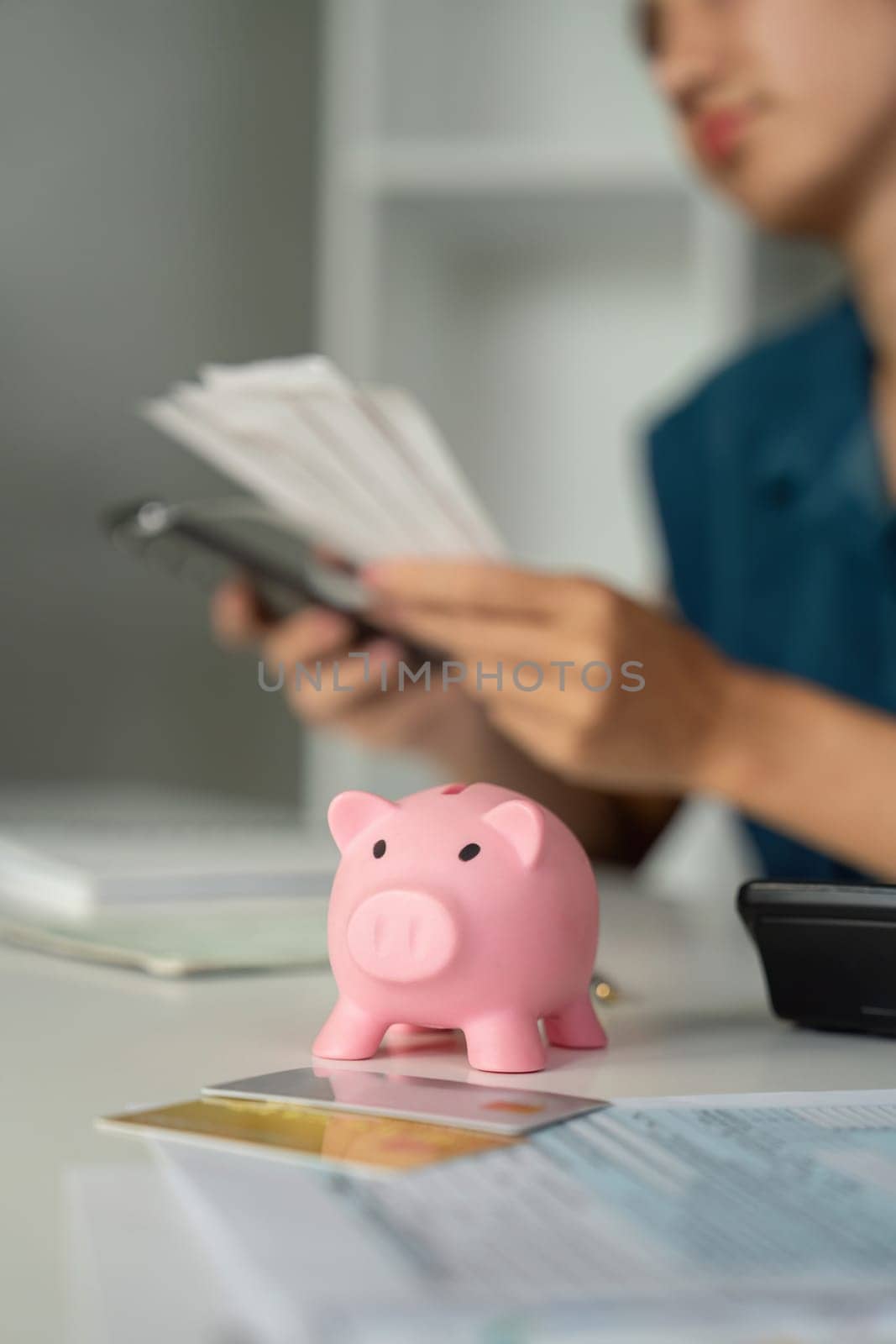 A focused individual assesses their savings strategy while gleefully interacting with a piggy bank, symbolizing financial health and smart choices.
