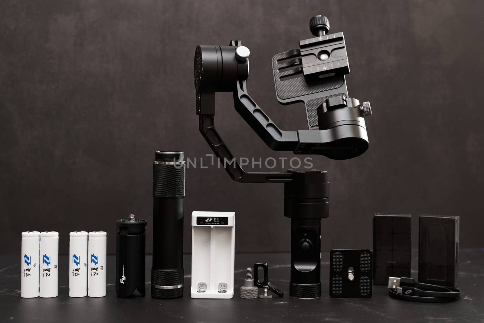 FeiyuTech G6 Steadicam with accessories stands on a marble table on a black background. High quality photo