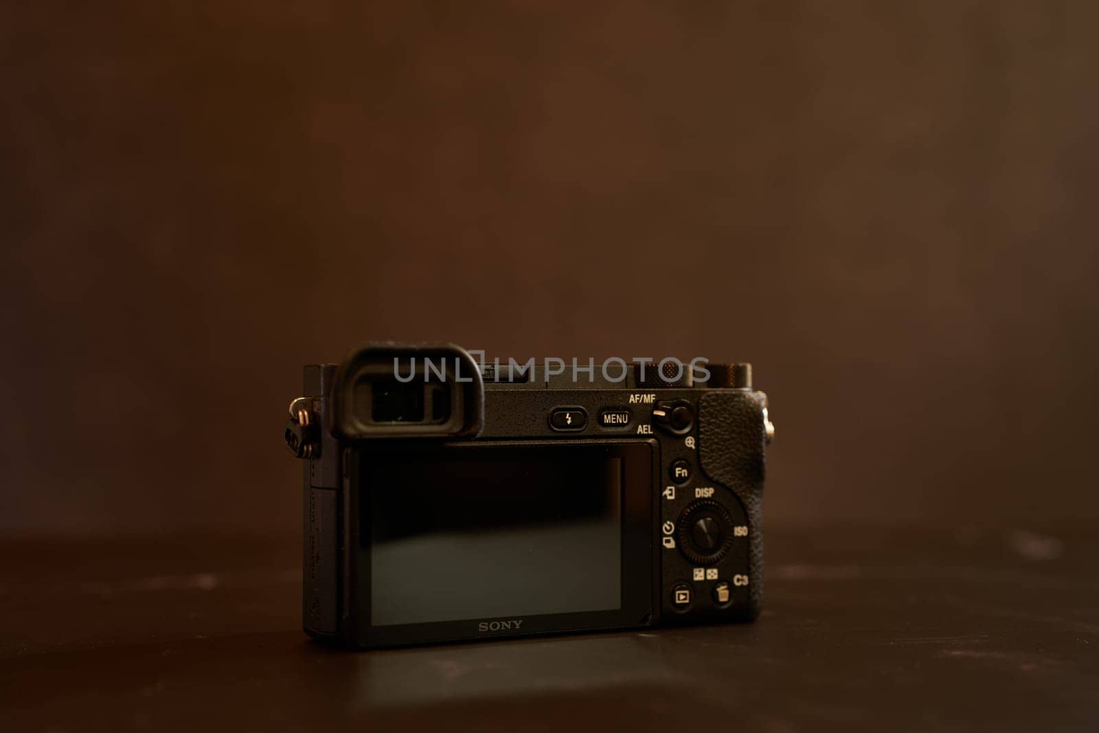 Sony A6000 mirrorless camera stands on a black table. High quality photo