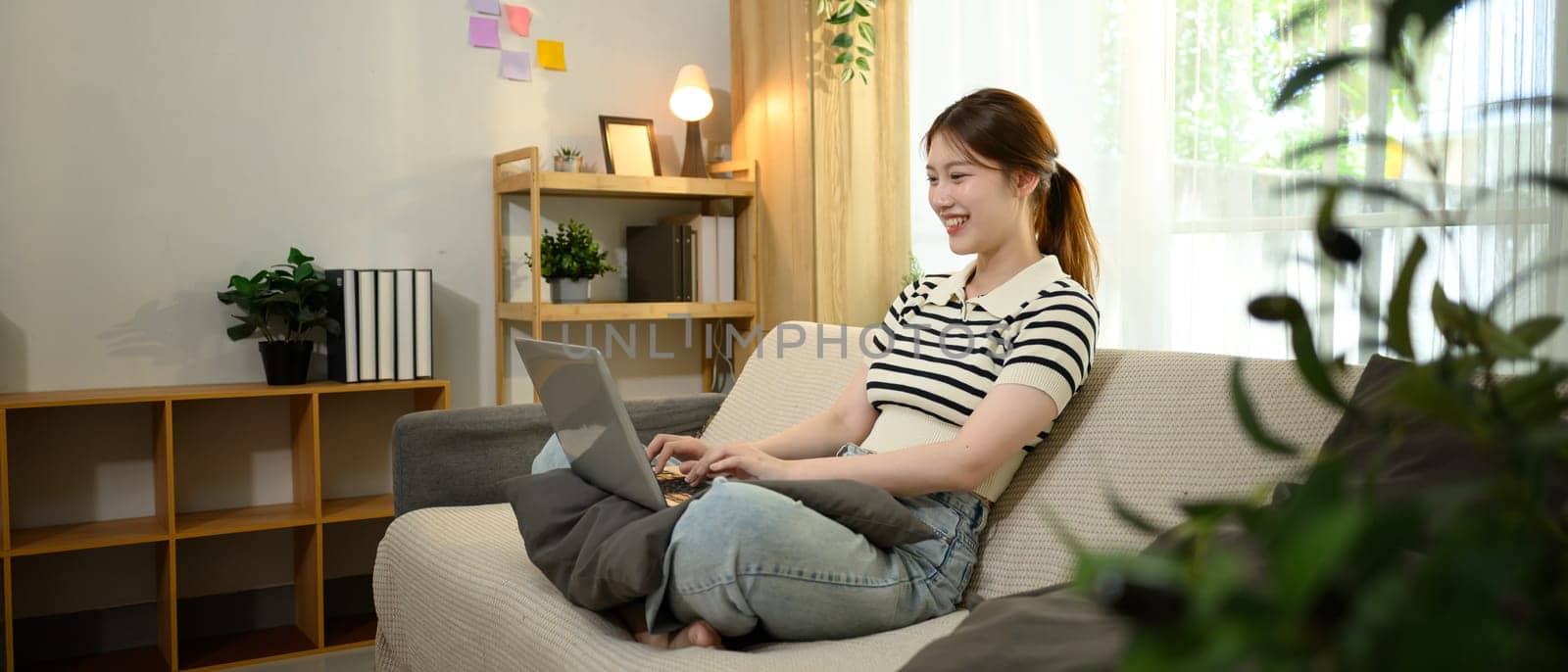Beautiful female freelancer in casual clothes working on her laptop at home.