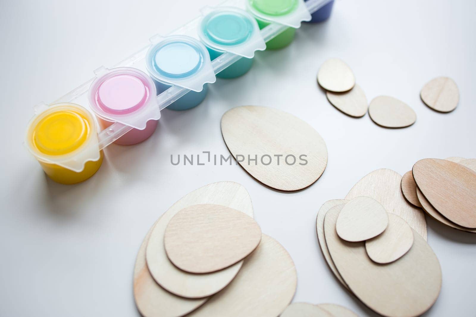 Assorted paints and wooden egg shapes for creative arts and crafts projects.