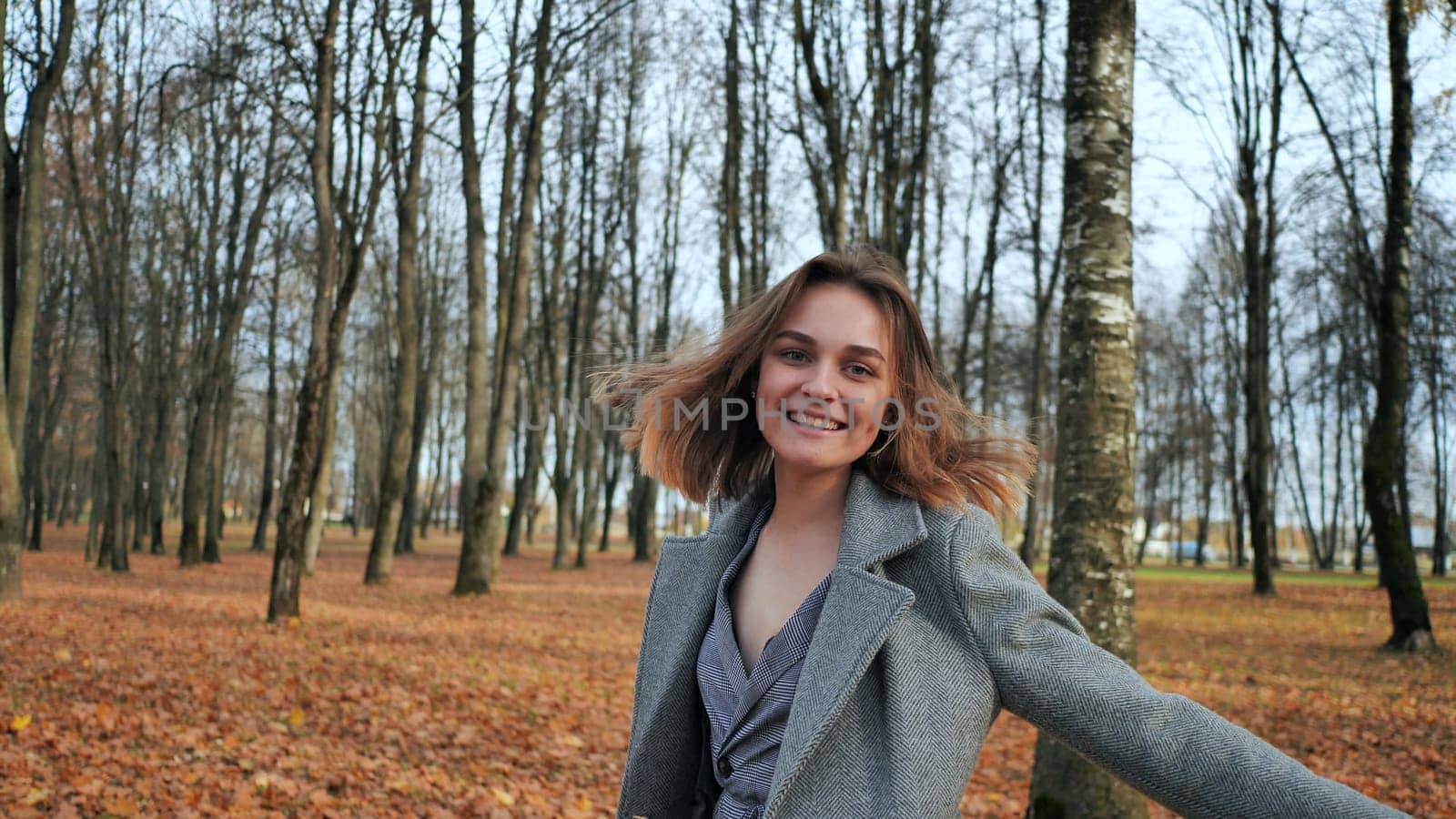 A beautiful and happy girl is walking in the autumn park
