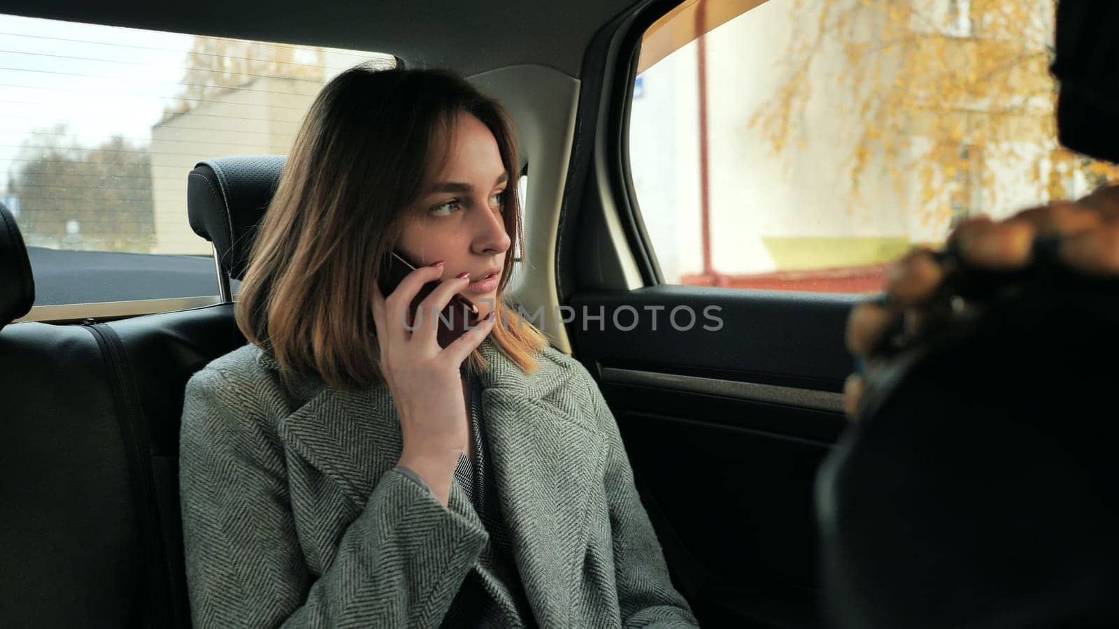 The girl in the car is talking on the phone