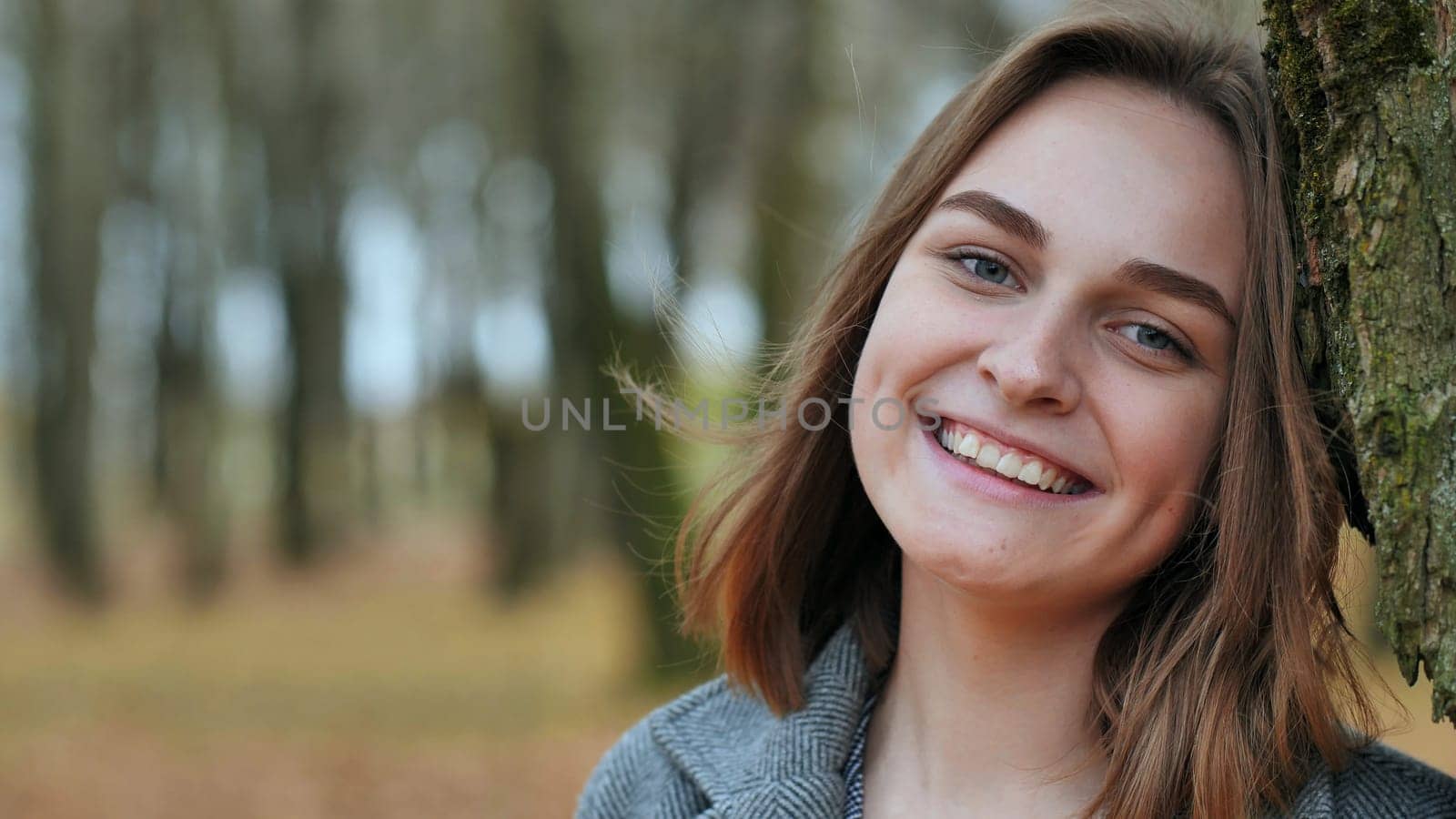 Beautiful happy smiling young girl in autumn park