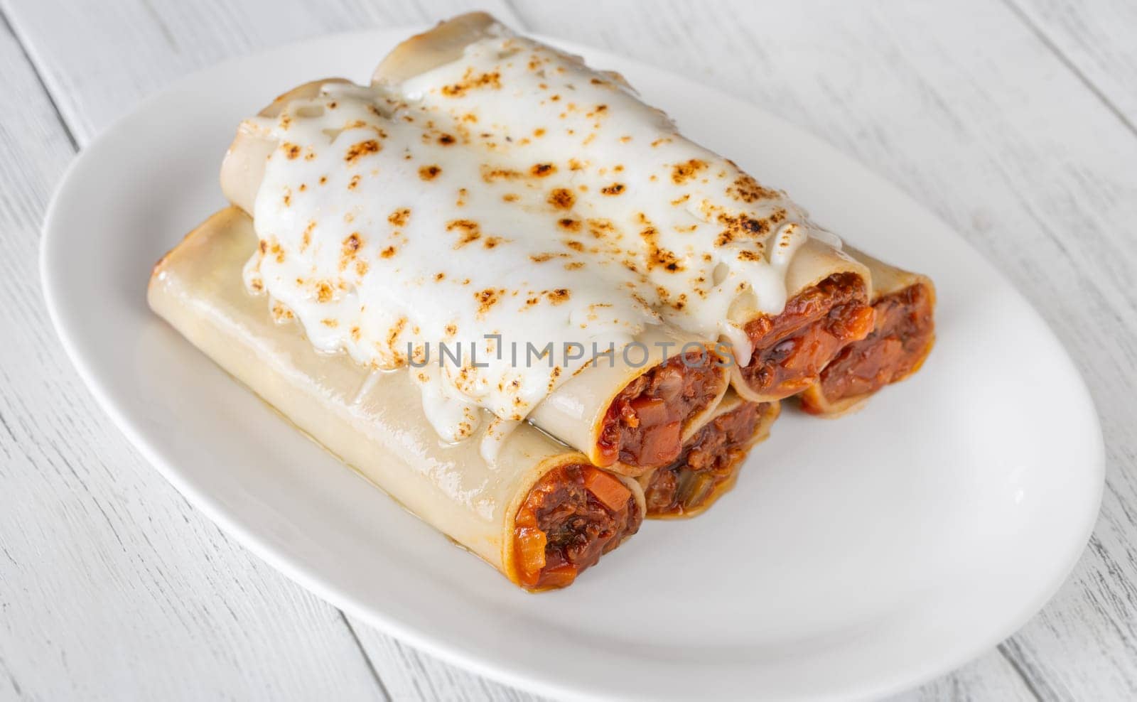 Delicate cannelloni pasta, generously filled with rich bolognese sauce, baked under a blanket of melted mozzarella