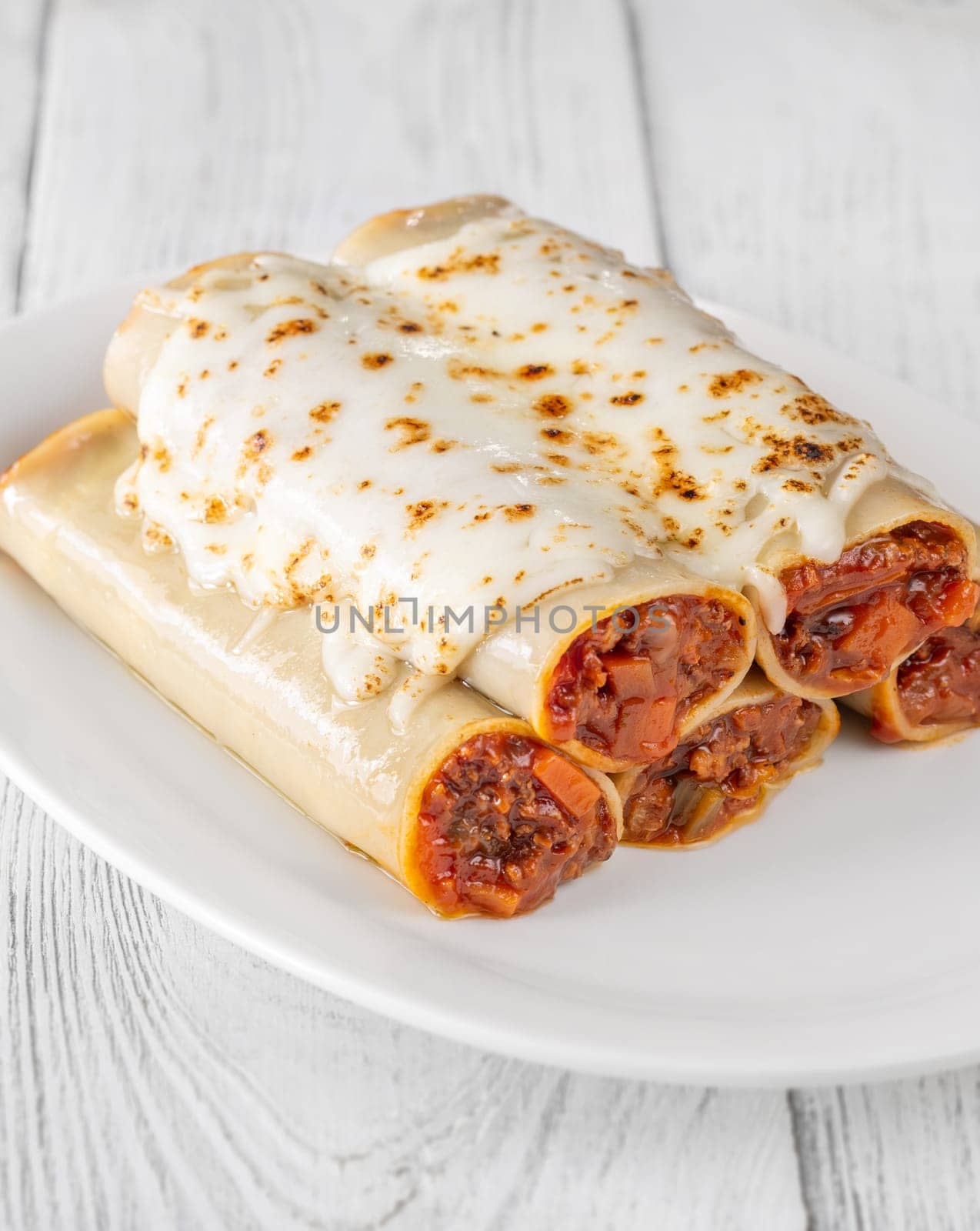 Delicate cannelloni pasta, generously filled with rich bolognese sauce, baked under a blanket of melted mozzarella