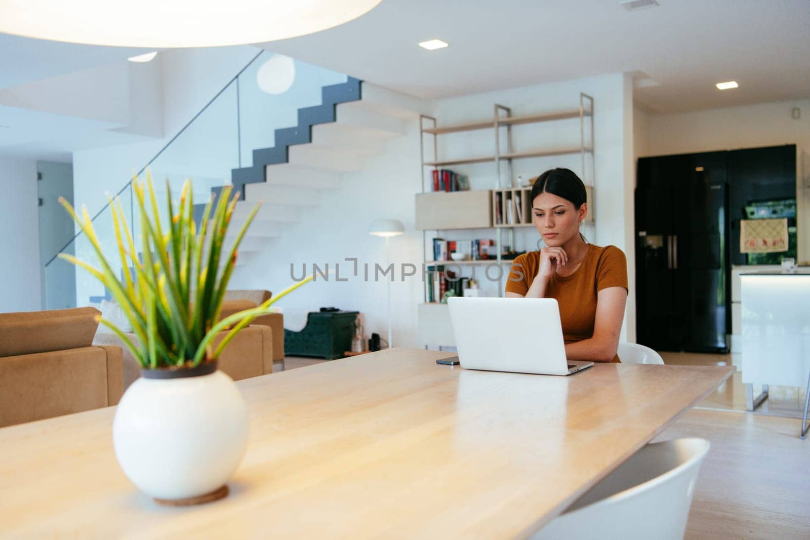 Woman sitting in living room using laptop looking at cam talk by video call with business friend relatives, head shot. Job interview answering questions
