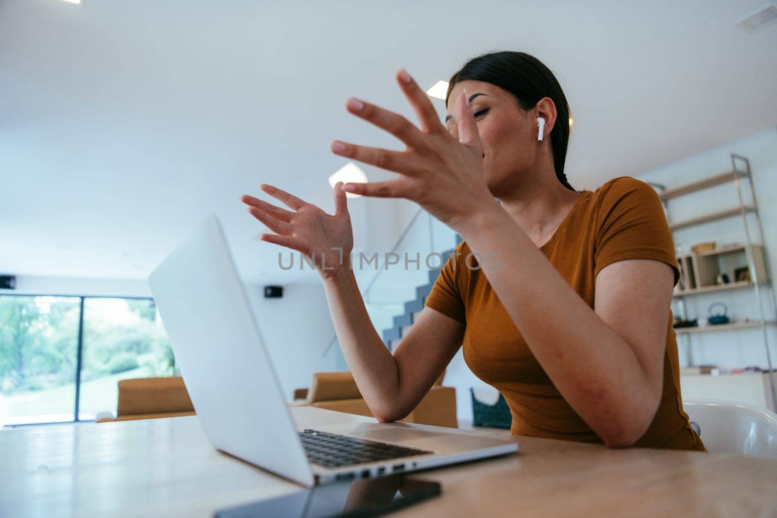 Woman sitting in living room using laptop looking at cam talk by video call with business friend relatives, head shot. Job interview answering questions