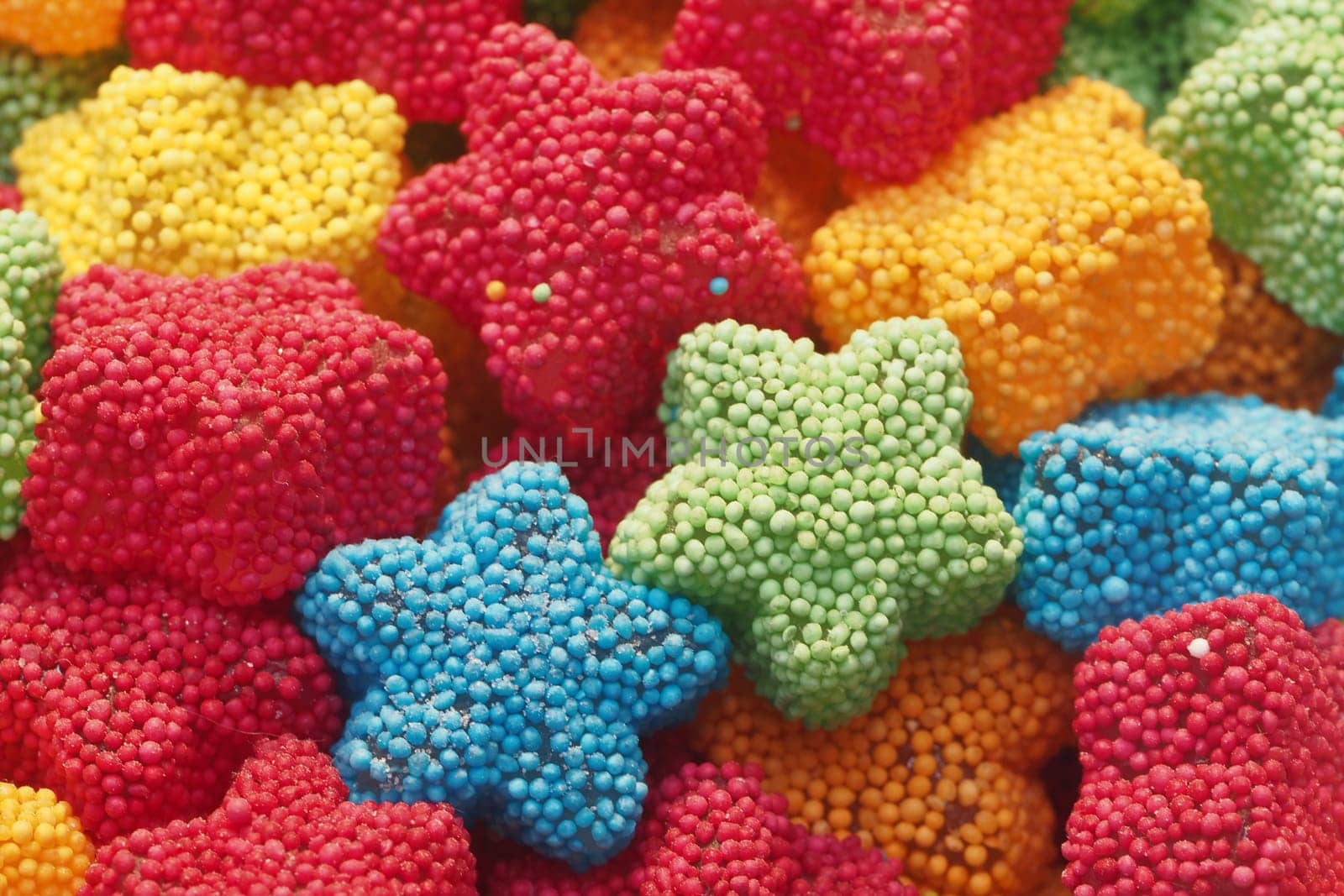 Brightly colored star-shaped candies in various hues create a cheerful display.