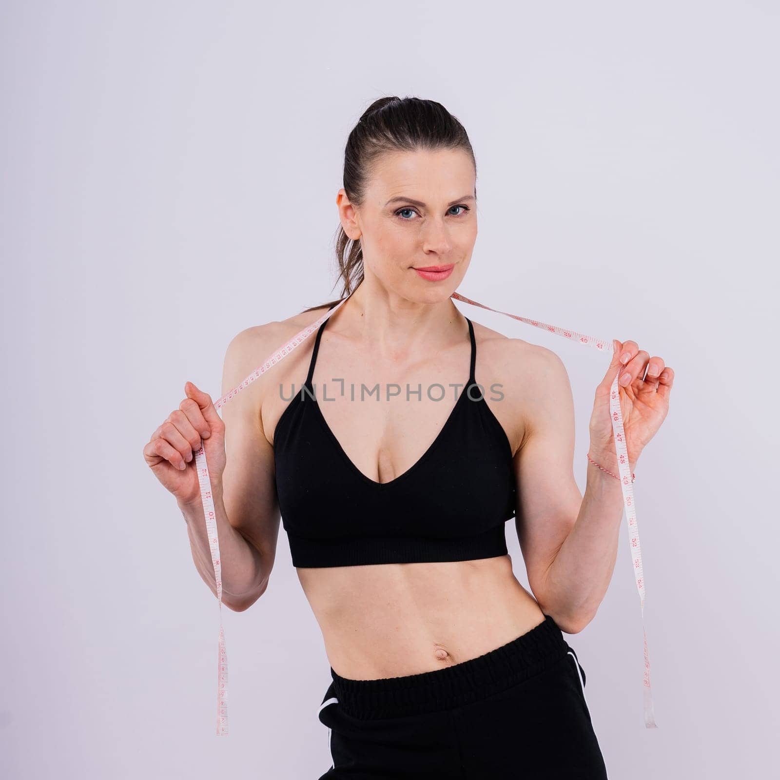 Weightloss, health and woman with measuring tape in studio for her diet, exercise or wellness.