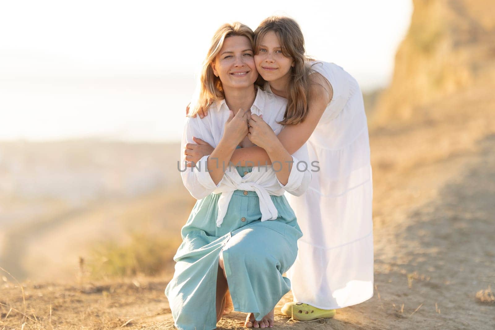 Daughter hugging her mother on a sunny beach, creating a heartwarming scene of family bonding