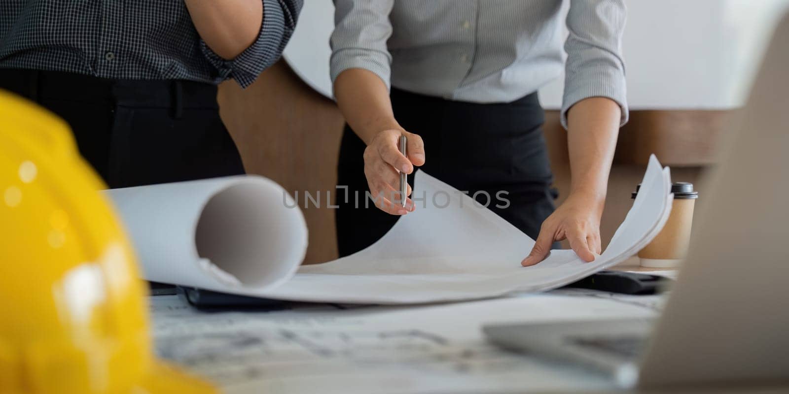 Detailed focus on engineers as they analyze and discuss essential project drawings and notes, underscoring the importance of thorough preparation in engineering endeavors.