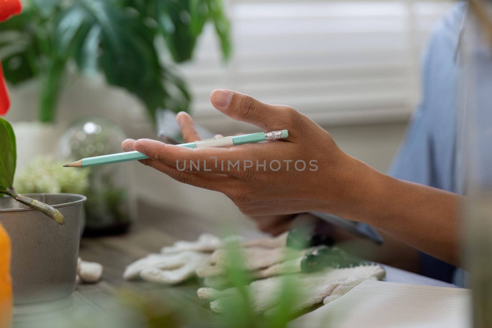 A dedicated individual prepares for sustainable gardening, showcasing hands covered in gloves while discussing plant care techniques. The focus is on environmental awareness.
