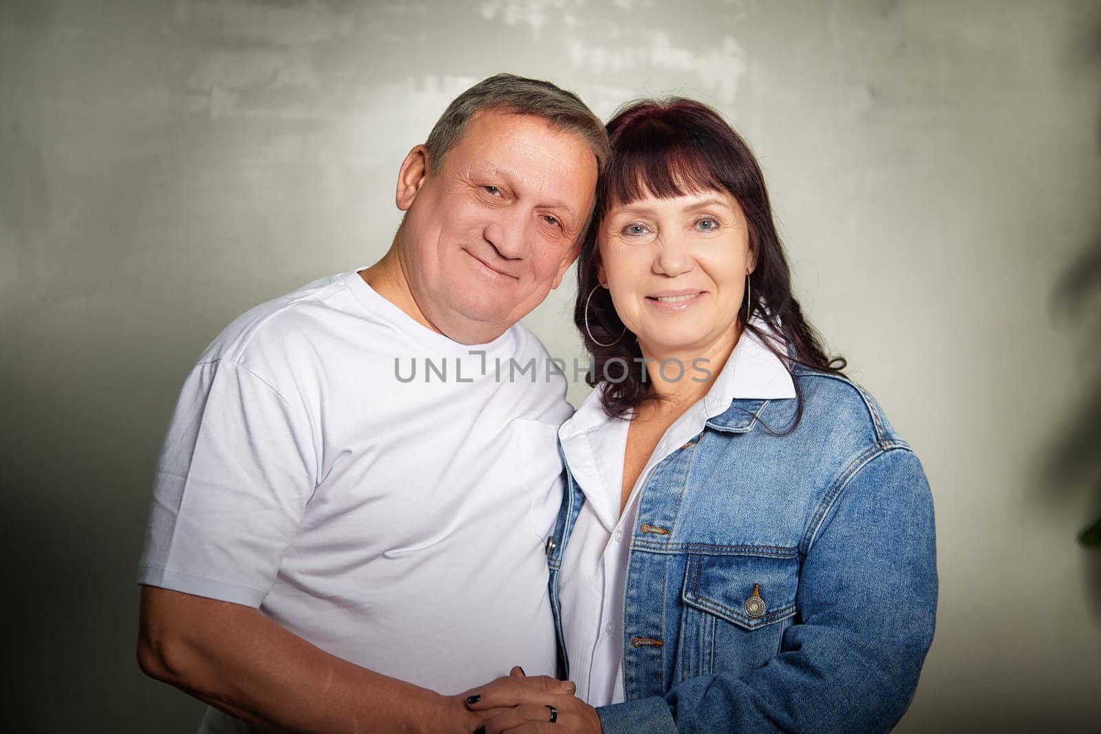 Middle-aged couple joyfully posing together inside their apartment, showcasing love and affection during a family photoshoot.